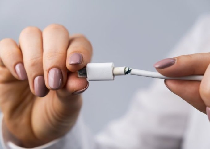 Kobieta widzi uszkodzenie kabla USB do smartfona